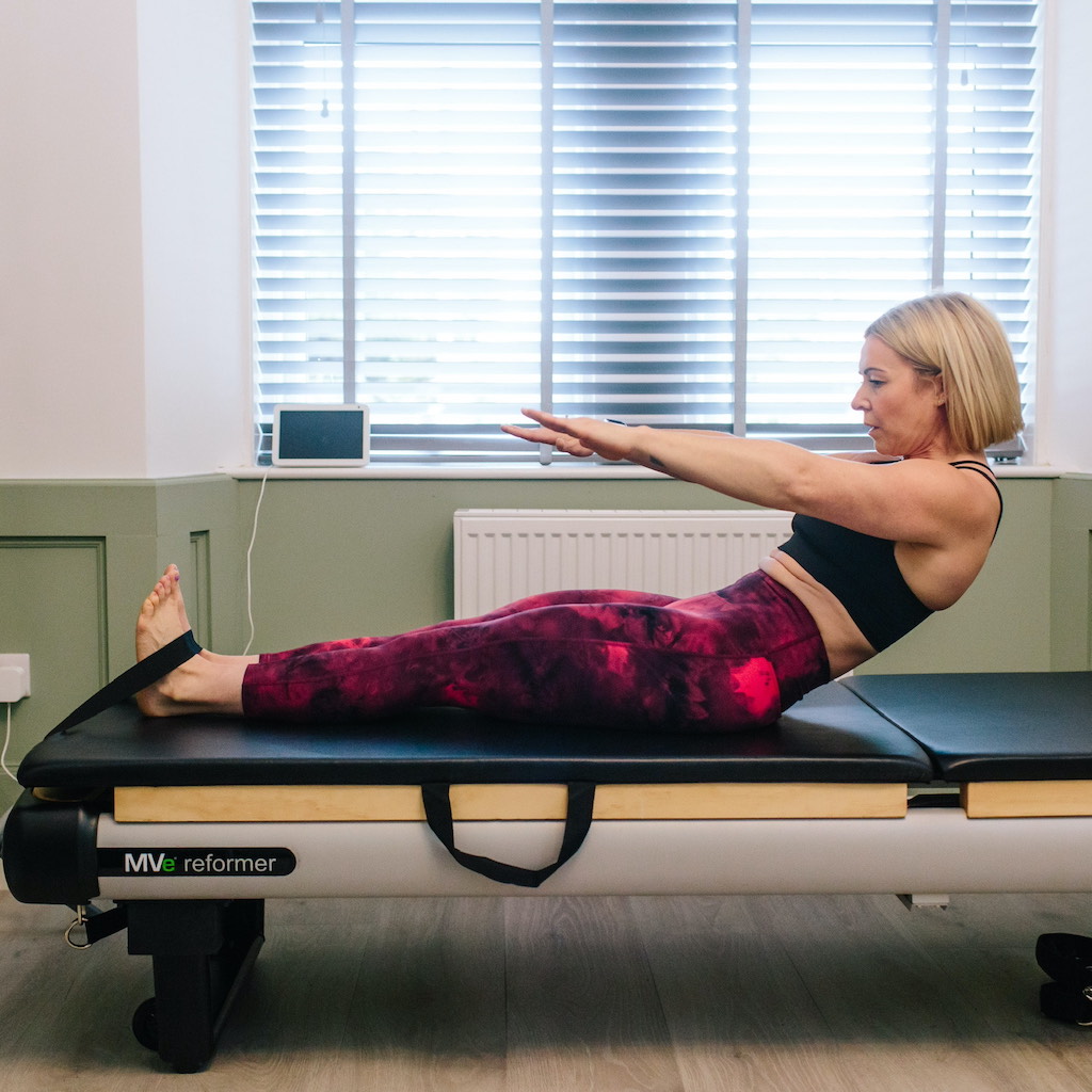 Woman doing exercise on Pilates reformer machine